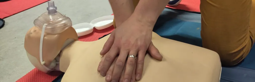 Person, die an einem Phantom Reanimation übt.